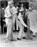 Idi Amin, deposed president of Uganda, photographed whilst still in power and being presented wirh a photograph by the hotel manager.